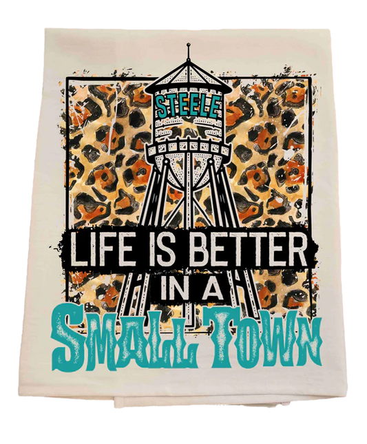 Towel with water tower graphic and text 'Life is better in a small town' on a white background